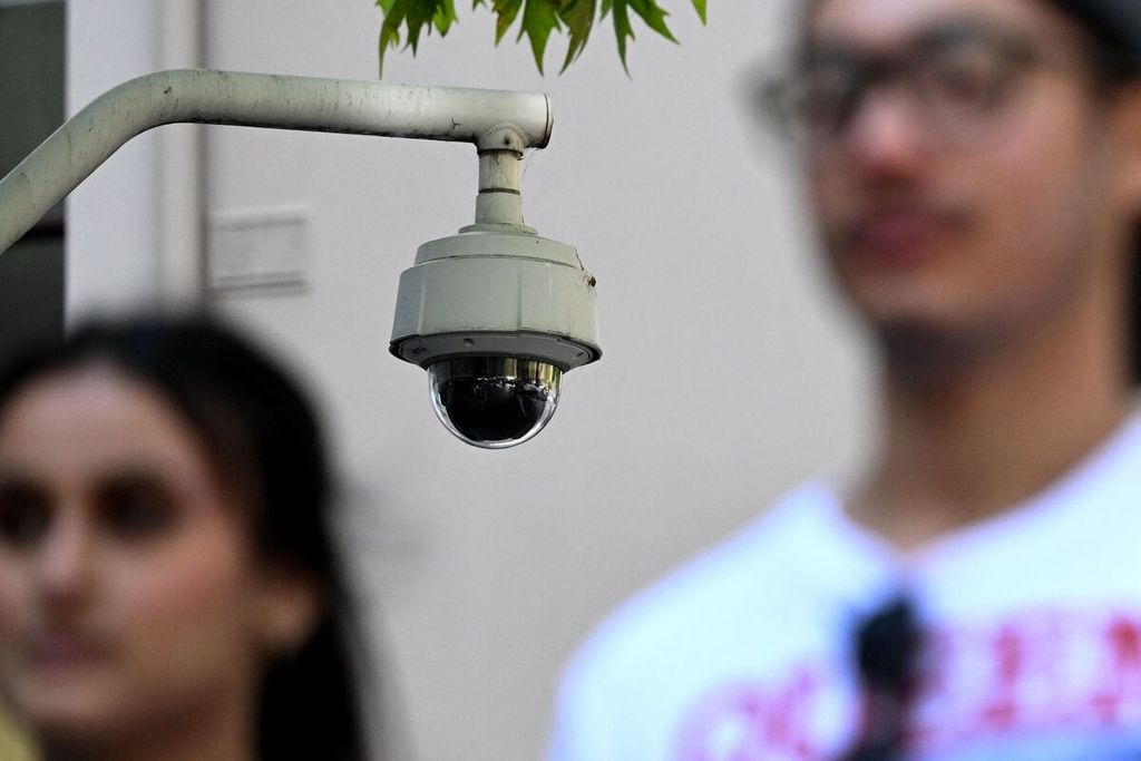 Warga berjalan melewati sebuah kamera pengawas keamanan di Melbourne, Australia, Rabu (9/2/2023). 