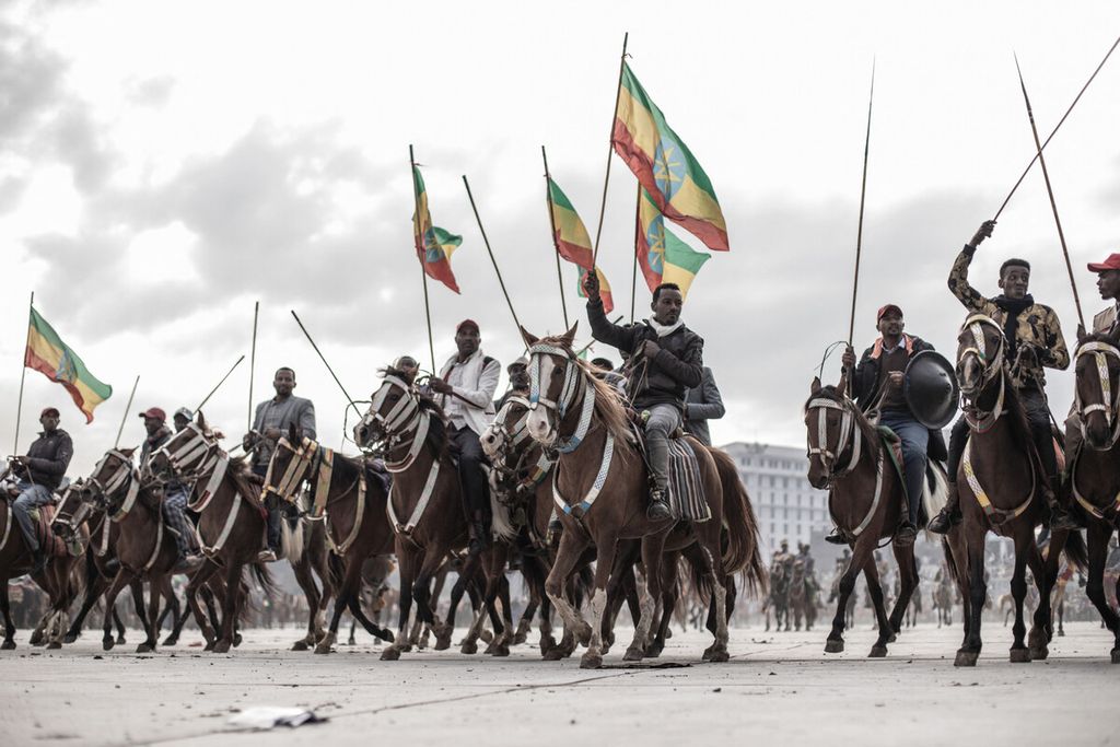 Sekelompok penunggang kuda membawa bendera nasional Etiopia saat unjuk rasa menentang pasukan pro-TPLF (Front Pembebasan Rakyat Tigray) dan mendukung angkatan bersenjata Etiopia di Addis Ababa, Etiopia, Minggu (8/8/2021). 
