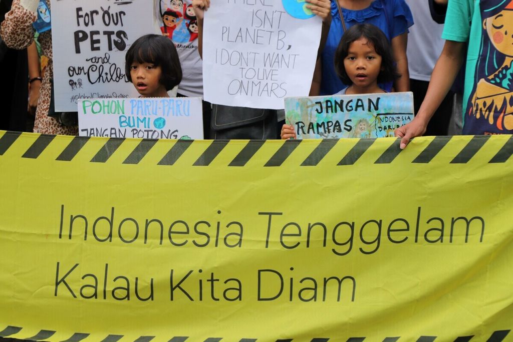 Anak-anak mengikuti aksi jeda untuk iklim dengan membawa poster di kawasan Jalan Jenderal Sudirman, Jakarta, Minggu, (23/2/2020). Aksi yang diikuti sekitar 150 orang ini untuk mendeklarasikan darurat iklim sebagai bentuk imbauan terhadap terjadinya perubahan iklim secara global. 