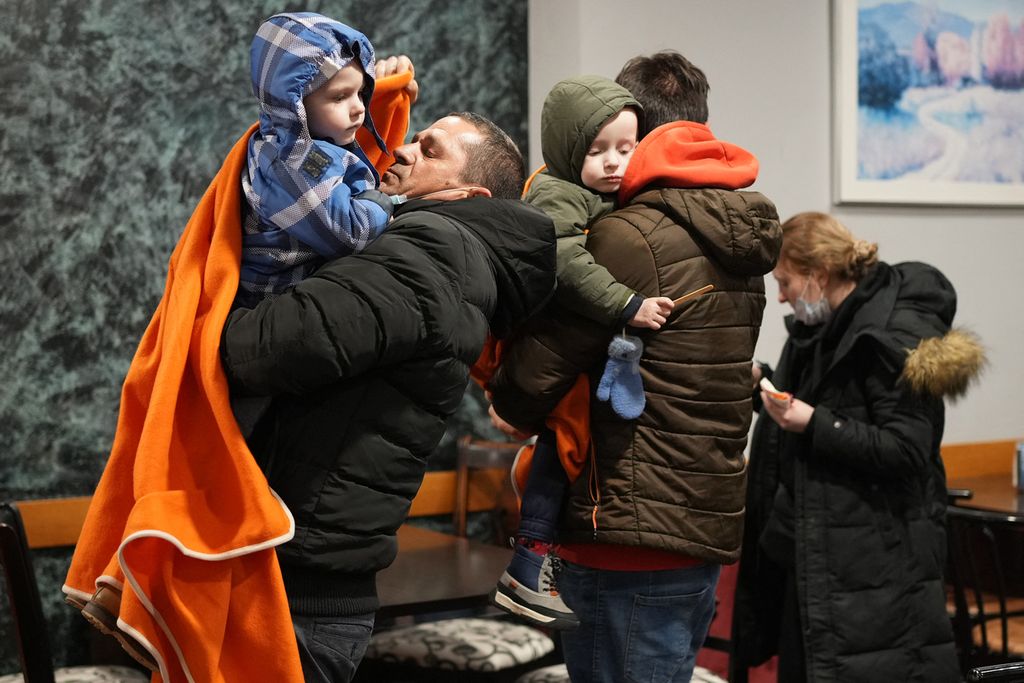 Dua pengemudi taksi menggendong anak-anak pengungsi Ukraina saat beristirahat di sebuah restoran pinggir jalan di Burgos, Spanyol, Rabu (16/3/2022). Anak-anak, lansia, serta wanita mendominasi pengungsi dari Ukraina.