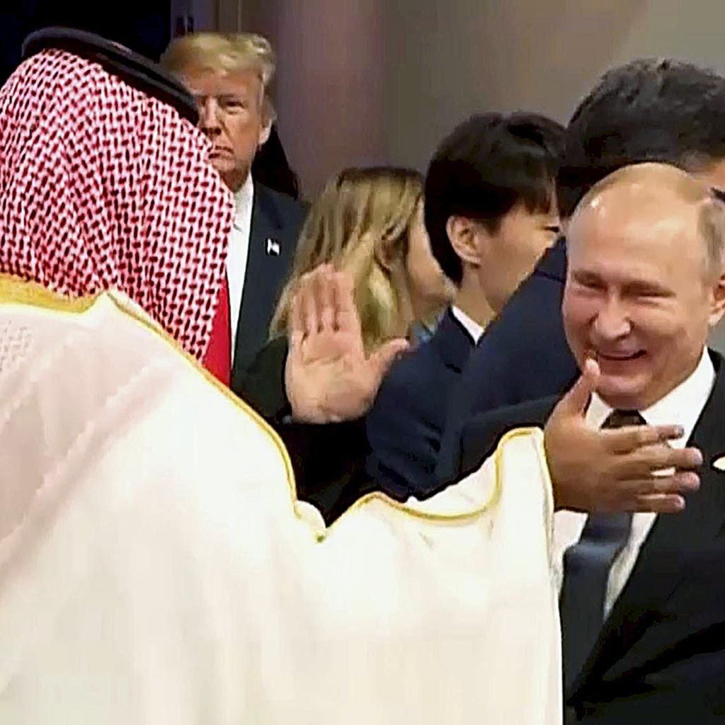 Presiden Rusia Vladimir Putin saling menepukkan tangan satu sama lain dengan Putra Mahkota Arab Saudi Pangeran Mohammed bin Salman dalam foto yang diambil dari tayangan video Konferensi Tingkat Tinggi G-20 di Buenos Aires, Argentina, Jumat (30/11/2018).
