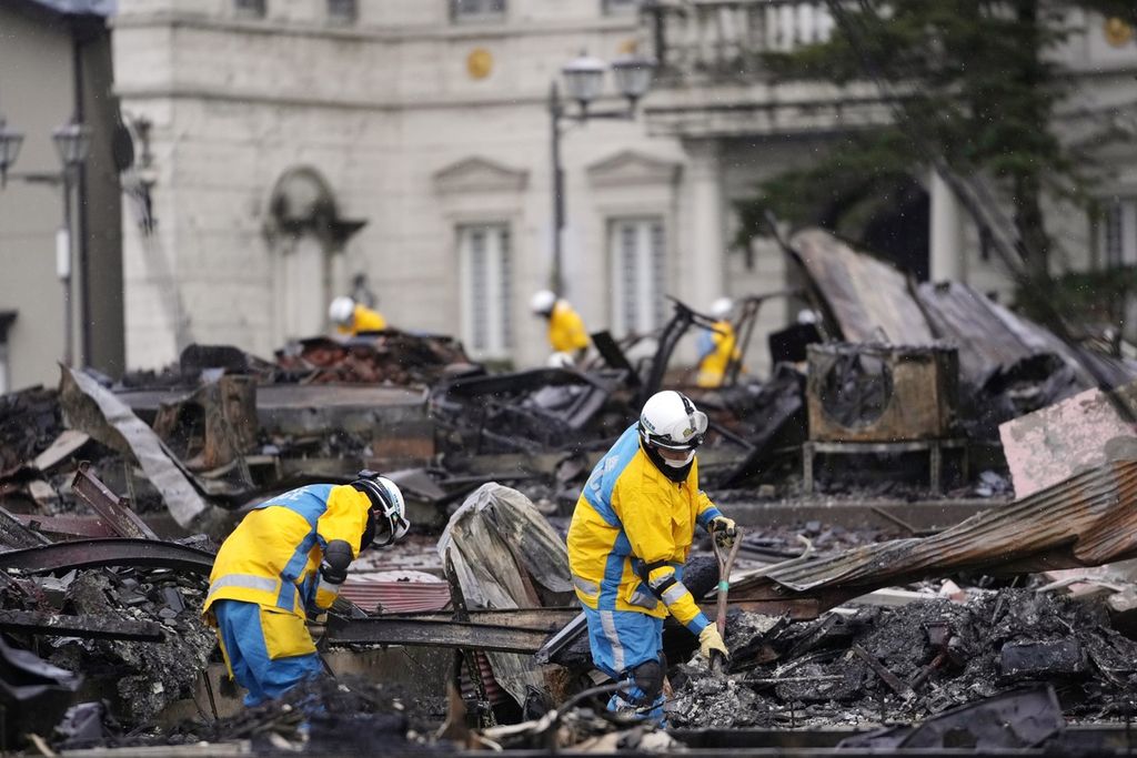 Petugas polisi mencari korban kebakaran akibat gempa bumi dahsyat di Wajima di semenanjung Noto yang menghadap ke Laut Jepang, barat laut Tokyo, Minggu (7/1/2024). 