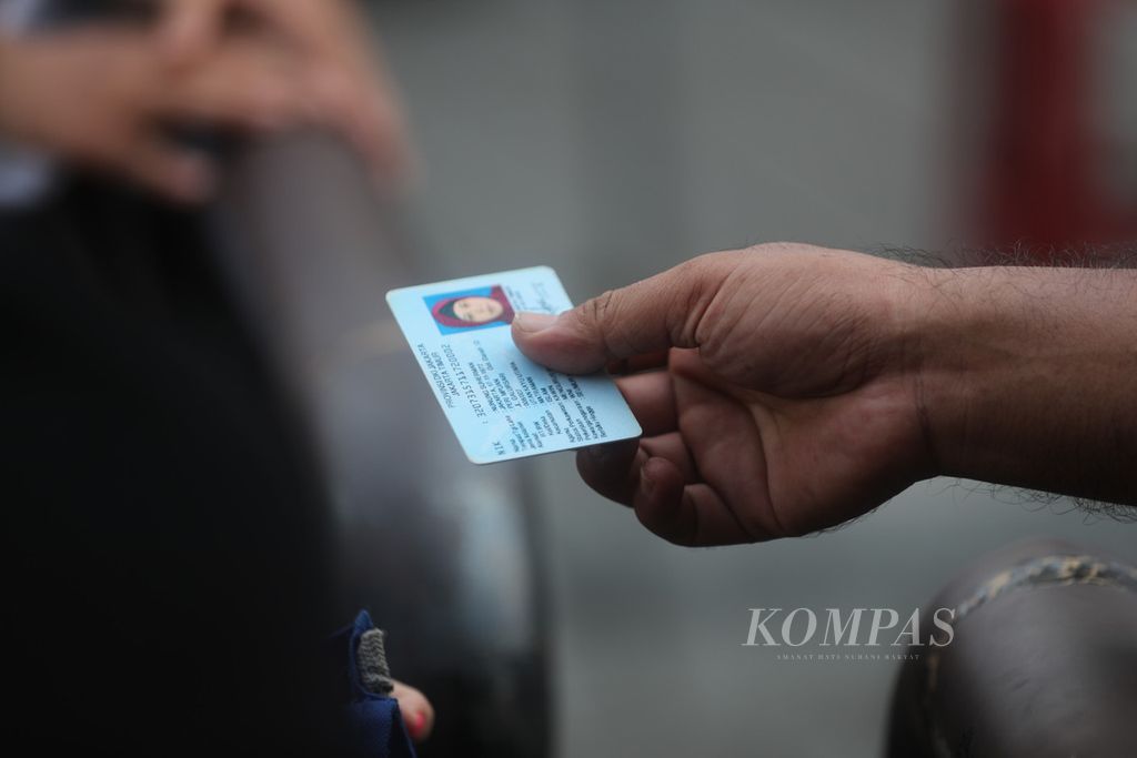 Warga menunjukkan KTP-nya kepada petugas yang berjaga ketika hendak memasuki kawasan wisata Kota Tua, Jakarta Barat, Sabtu (15/5/2021). 