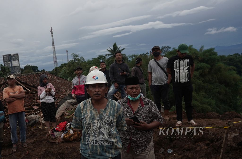 Sejumlah warga menyaksikan petugas SAR melakukan pencarian korban yang tertimbun longsor di Cijedil, Kabupaten Cianjur, Jawa Barat, Kamis (24/11/2022).