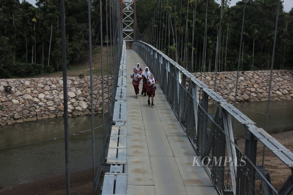 Siswa melintasi jembatan gantung di Desa Siron, Kecamatan Cot Glie, Kabupaten Aceh Besar, Provinsi Aceh, Kamis (16/3/2023). 