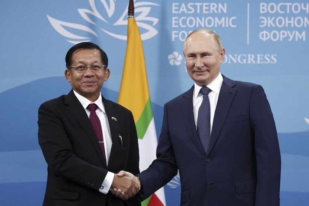 Presiden Rusia Vladimir Putin tersenyum saat berjabat tangan dengan pemimpin kudeta militer Myanmar Jenderal Min Aung Hlaing saat bertemu di Vladivostok, Rusia, Rabu (7/9/2022). Rusia adalah salah satu tulang punggung militer Tatmadaw, sebutan bagi militer Myanmar, meski mendukung ASEAN untuk menyelesaikan konflik di negara tersebut. 