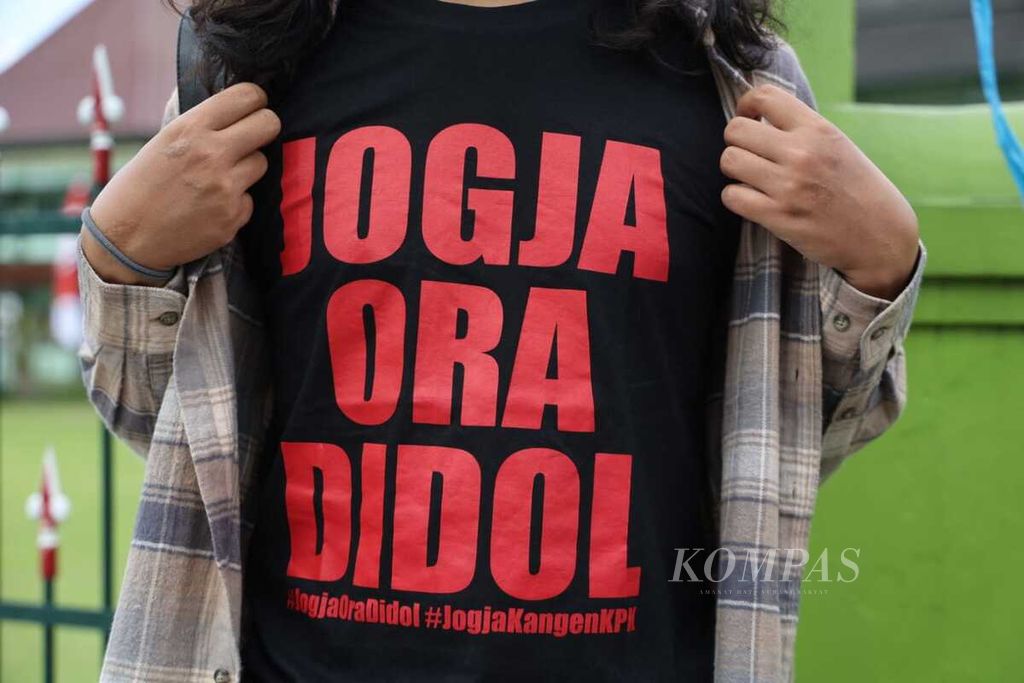 Seorang warga menggunakan kaus bertuliskan Jogja Ora Didol atau Jogja Tidak Dijual dalam aksi cukur gundul yang digelar aktivis asal Yogyakarta, Dodo Putra Bangsa, di depan Balai Kota Yogyakarta, Sabtu (4/6/2022).