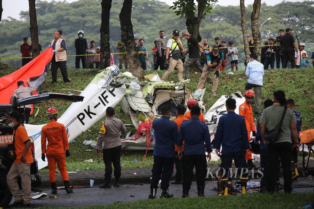 Petugas memeriksa puing-puing pesawat berjenis TecnamP2006T dengan nomor registrasi PK-IFP yang jatuh di kawasan BSD, Serpong, Tangerang Selatan, Banten, Minggu (19/5/2024). Tiga orang tewas dalam kecelakaan pesawat latih ini.