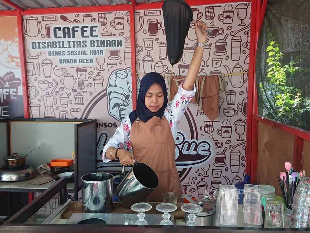 Tari Tiaralita Putri (25), seorang teman tuli, sedang meracik kopi di Cafe Hanasue Dinas Sosial Banda Aceh, Kamis (22/9/2022). Tari adalah barista rungu yang kini aktif mengampanyekan kesetaraan.