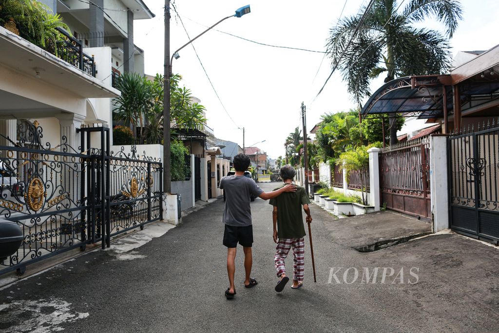 Aria menemani bapaknya, Sri Warso Wahono (74), berkeliling kompleks setiap pagi di kawasan Palmerah, Jakarta Barat, Rabu (25/5/2022).