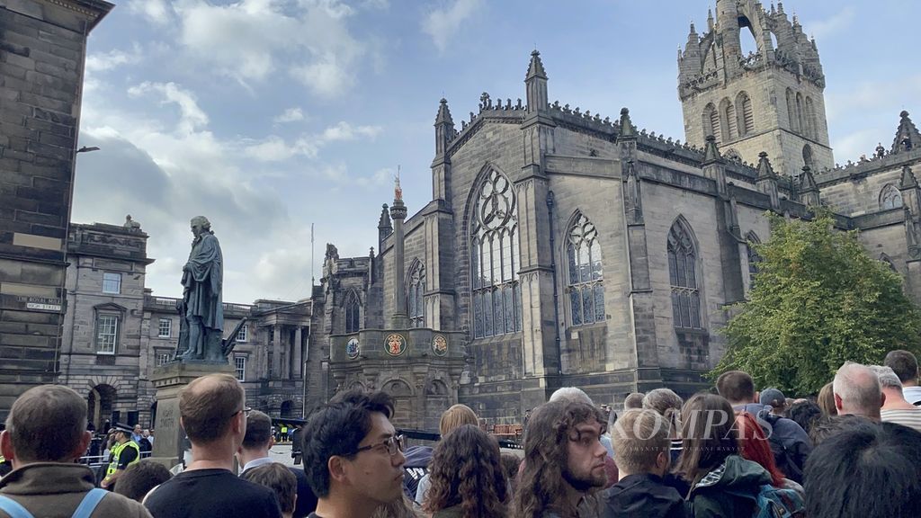Suasana di depan Katedral St Giles’ di jalan Royal Mile, Edinburgh, Skotlandia, Minggu (11/9/2022). Warga terlihat memadati trotoar depan katedral sejak sebelum pukul 11.00 untuk menunggu kedatangan jenazah Ratu Elizabeth II.