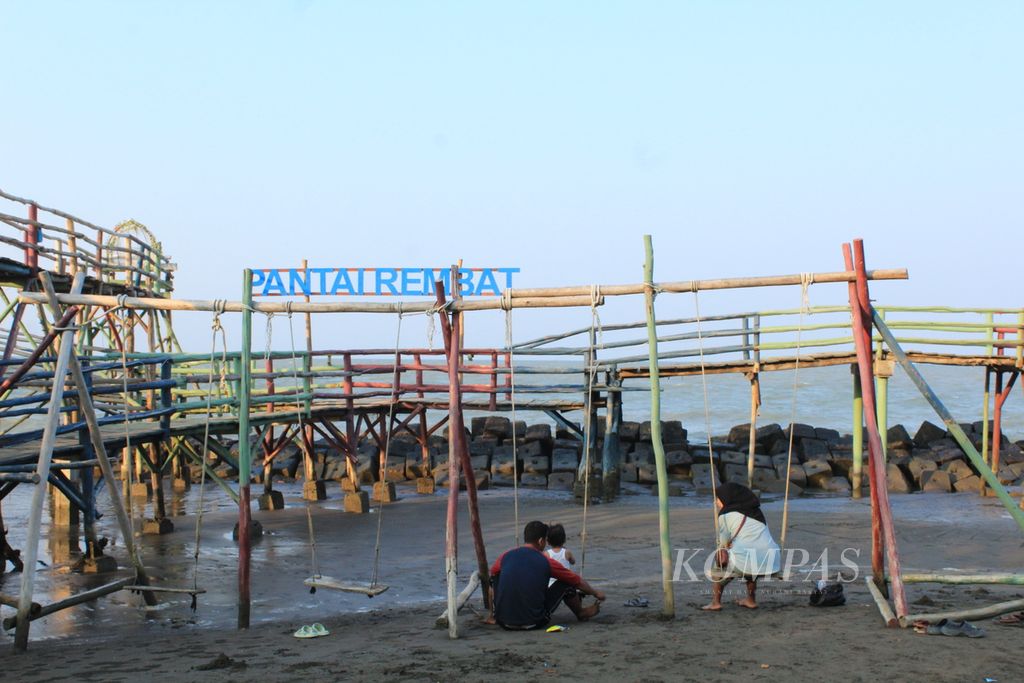 Pengunjung bersantai di Pantai Rembat di Desa Juntinyuat, Kecamatan Juntinyuat, Kabupaten Indramayu, Jawa Barat, Senin (30/10/2023) sore. 