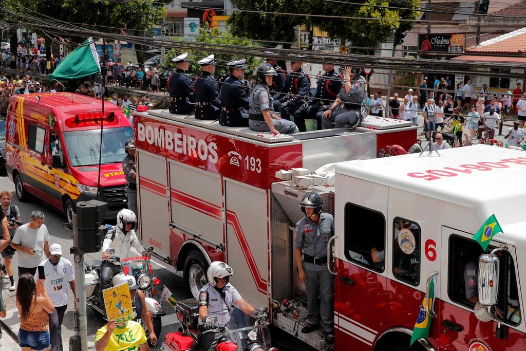 Warga berkerumun di sepanjang jalan yang dilewati iring-iringan kendaraan pembawa jenazah Pele menuju tempat pemakaman Santos Memorial di Santos, Sao Paulo, Brasil, Selasa (3/1/2023). 