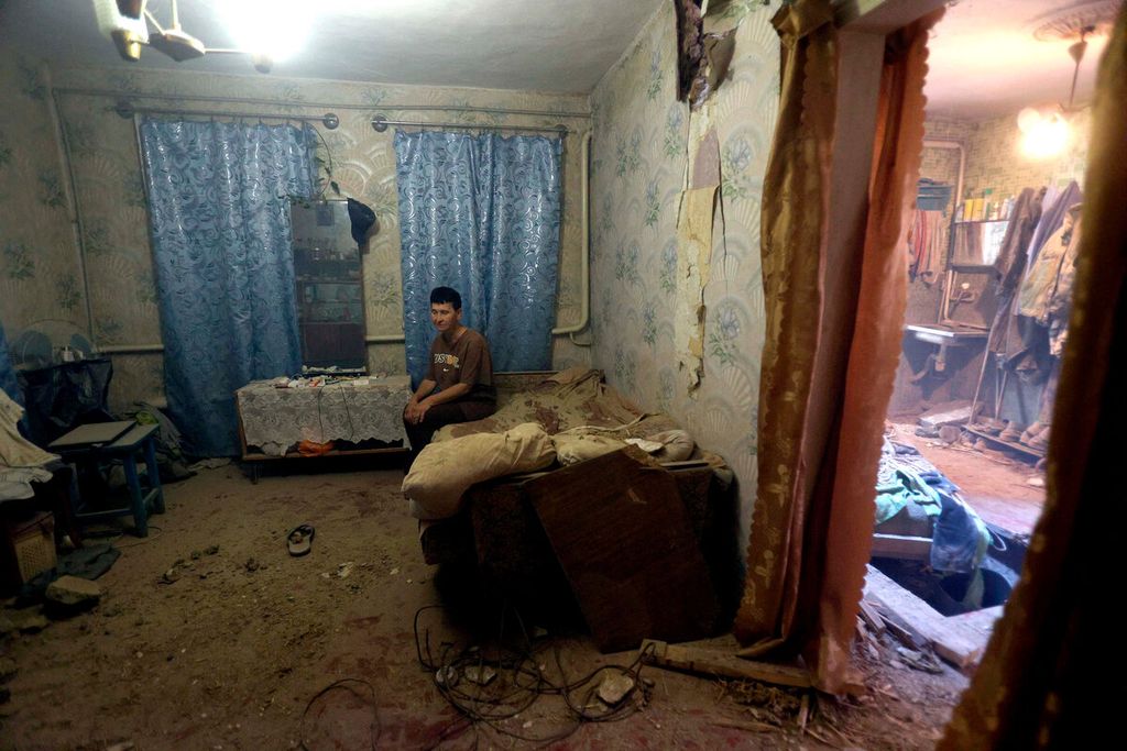 Warga berada di dalam sebuah ruangan rumahnya yang hancur karena terjadinya perang antara Rusia dan Ukraina di Donetsk, Urkaina, Senin (25/7/2022).