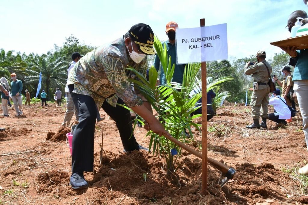 Penjabat Gubernur Kalimantan Selatan Safrizal ZA menanam bibit sawit dalam acara penanaman sawit sebagai simbolis pelaksanaan program Peremajaan Sawit Rakyat di Desa Kait-Kait, Kecamatan Bati-Bati, Kabupaten Tanah Laut, Senin (12/4/2021).