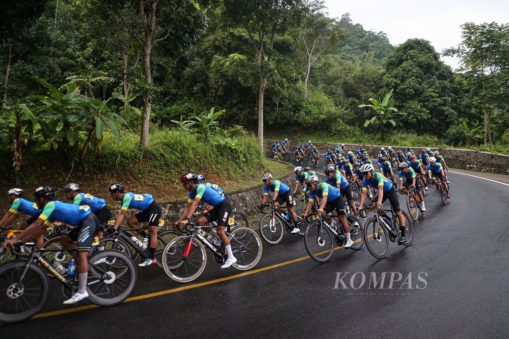 Participants in the Cycling de Jabar 2024 bicycle race cross curves in Kuningan Regency, West Java, Saturday (25/5/2024). 