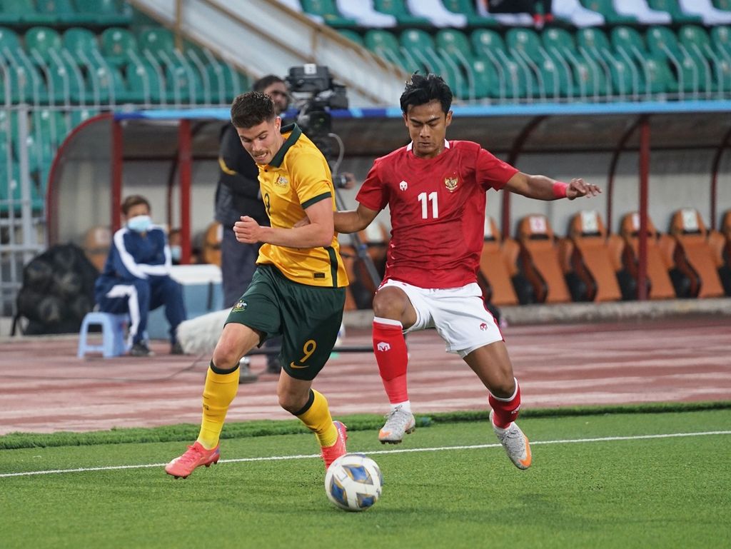 Bek kiri Indonesia, Pratama Arhan, berusaha merebut bola dari penguasaan penyerang Australia, Patrick Wood, pada laga kualifikasi Piala Asia U-23 2022 di Stadion Utama Tajikistan, Dushanbe, Jumat (29/10/2021) malam WIB. Indonesia kalah 0-1 sehingga gagal lolos ke putaran final.