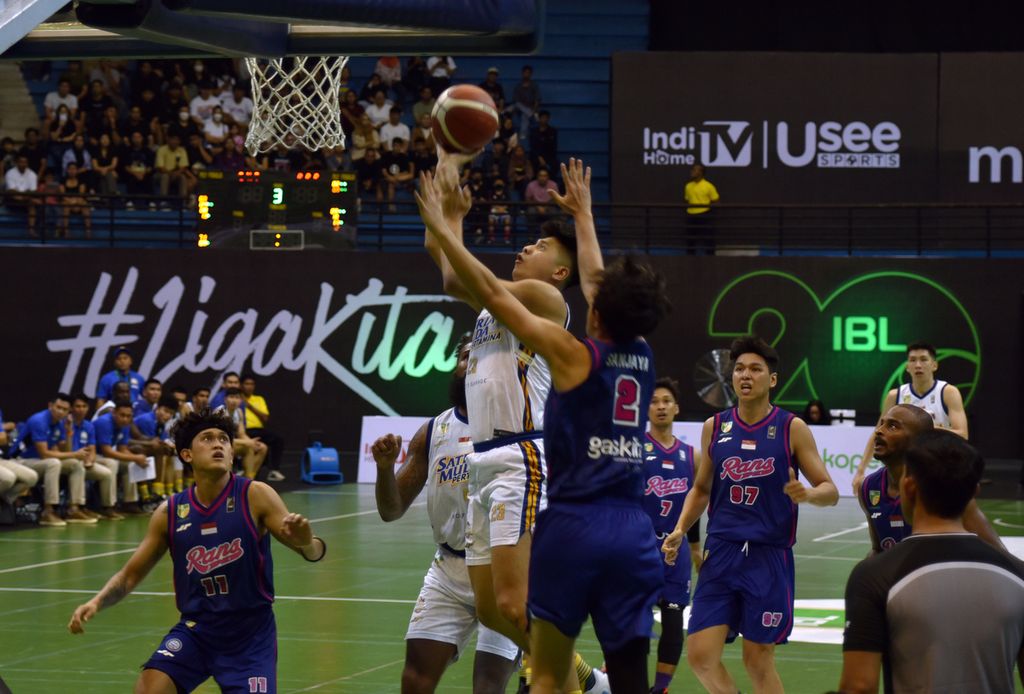 Pemain Satria Muda Pertamina Jakarta, Avan Seputra (putih), berupaya melakukan <i>lay up </i>di antara pengawalan pemain RANS PIK Basketball Club dalam seri keenam Liga Bola Basket Indonesia IBL 2023 di GOR Amongraga, Yogyakarta, Rabu (24/5/2023). 