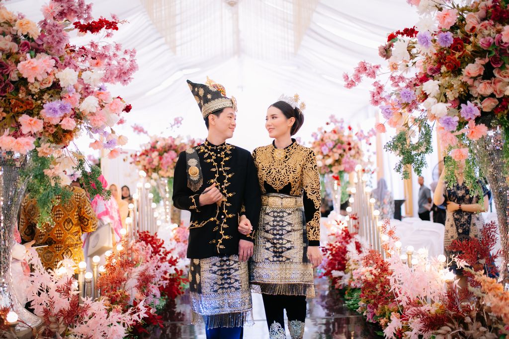 Andriano David (30) dan istrinya, Desi Mandasari (28), saat merayakan resepsi pernikahan di Meulaboh, Kabupaten Aceh Barat, Provinsi Aceh, Senin (2/10/2023). Meski warga keturunan Tionghoa, Andriano dan Desi memilih mengenakan pakaian adat Aceh.