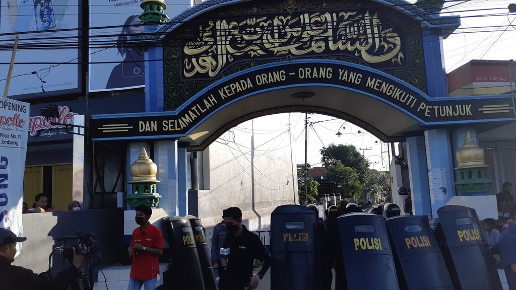 Polisi berjaga di pintu masuk Pesantren Shiddiqiyah, Jombang, Kamis (7/7/2022). Ratusan personel dikerahkan untuk menangkap pelaku kekerasan seksual terhadap santri, MSA ,yang merupakan putra pengasuh pondok
