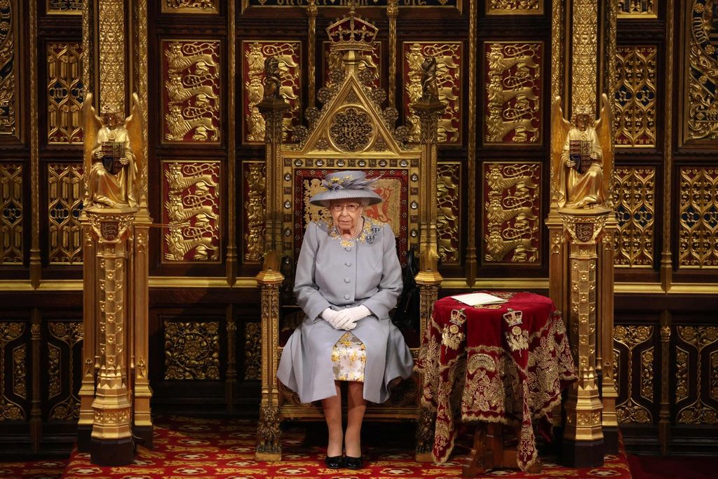 Dalam foto yang diambil pada 11 Mei 2021 ini tampak Ratu Elizabeth II duduk di kursi kehormatan The Sovereign's Throne saat pembukaan sidang parlemen di London. 