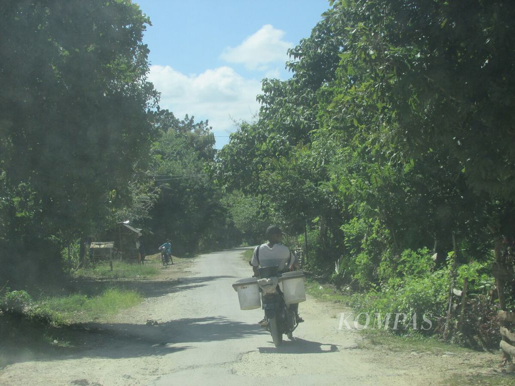 Seorang pedagang berkeliling menggunakan sepeda motor menuju Desa Bokong, Kecamatan Taebenu, Kabupaten Kupang, Nusa Tenggara Timur, Kamis (25/4/2024).