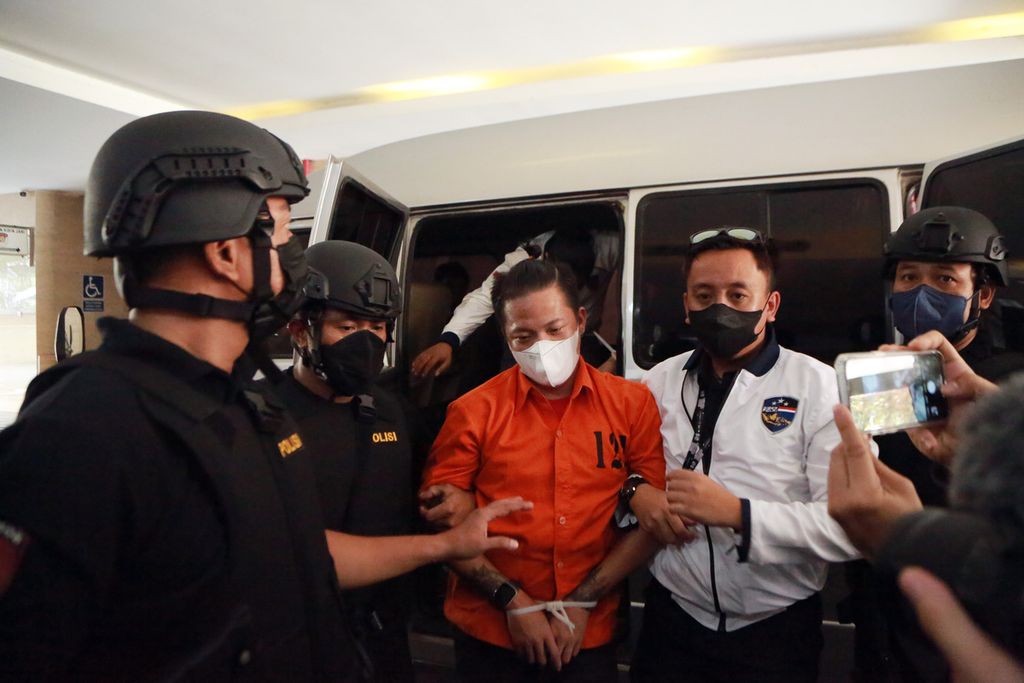 Petugas kepolisian menggelandang salah satu tersangka kasus judi dalam jaringan atau<i> online</i> ke Bareskrim Polri, Jakarta Selatan, Sabtu (15/10/2022). 