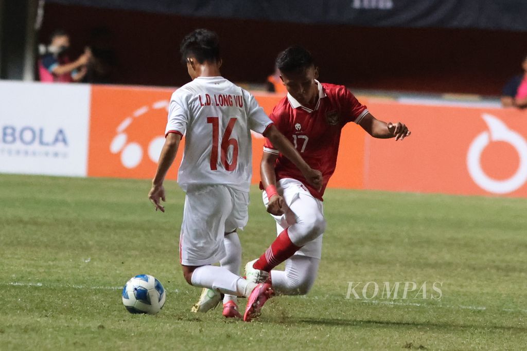 Pemain Tim Indonesia U-16 Muhammad Nabil Asyura (kanan) berebut bola dengan pemain Tim Vietnam U-16 Le Dinh Long Vu dalam laga Piala AFF U-16 di Stadion Maguwoharjo, Sleman, DI Yogyakarta, Sabtu (6/8/2022). Indonesia menang dengan skor 2-1.