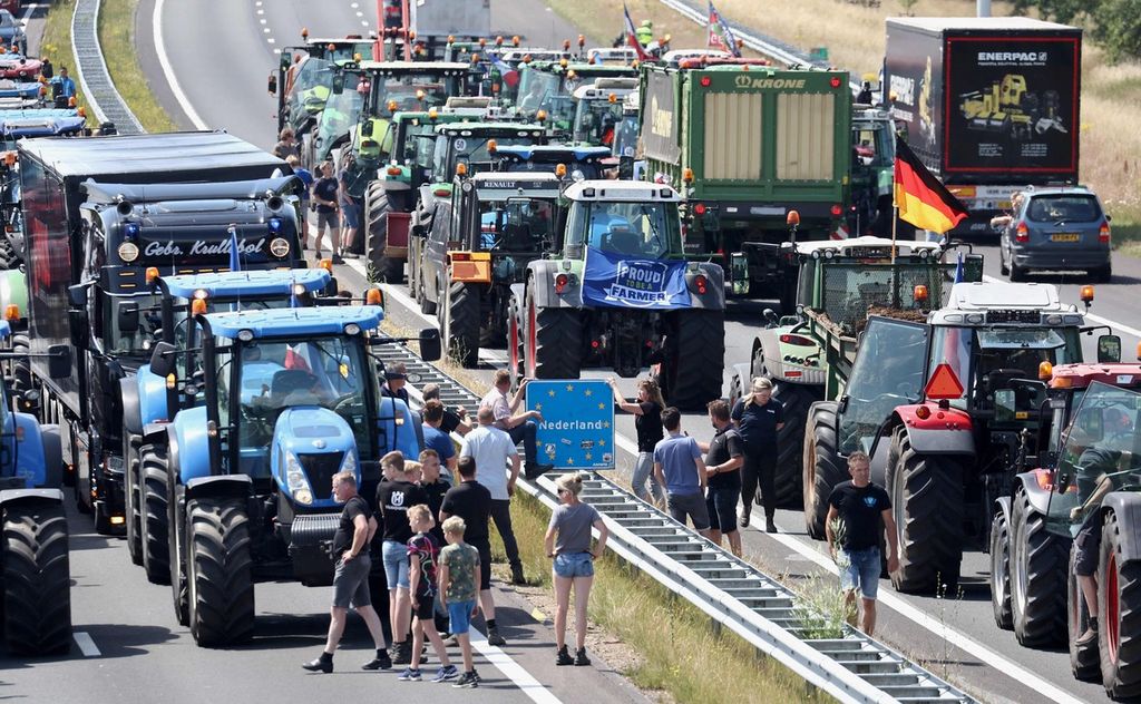 Para petani memarkir traktor mereka di jalur bebas hambatan di perbatasan Belanda-Jerman tak jauh dari Rijssen pada Rabu (29/6/2022).