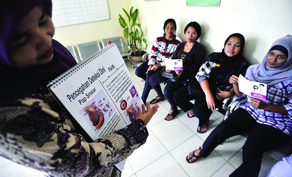 Tetty (kiri), kader penyuluh kesehatan Kelurahan Srengseng Sawah, melakukan simulasi penyuluhan pencegahan kanker serviks saat peluncuran program Bulan Cegah Kanker Seviks di Puskesmas Jagakarsa, Jakarta Selatan, Kamis (22/12).  