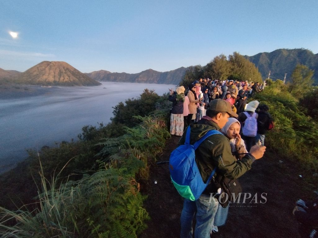 Wisatawan menikmati keindahan alam di kawasan Taman Nasional Bromo Tengger Semeru dari bukit Mentingen, Ngadisari, Sukapura, Probolinggo, Jawa Timur, Selasa (4/7/2023). 