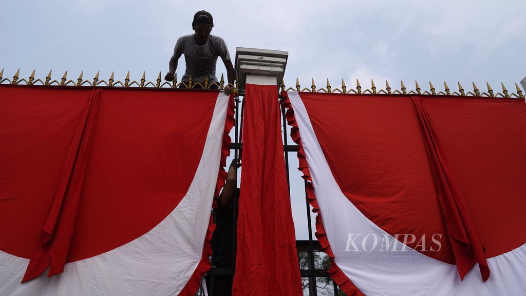Pekerja memasang umbul-umbul gelombang merah putih di pagar Gedung DPR, Jakarta, Kamis (27/7/2023). Sepanjang pagar Gedung DPR dipercantik dengan nuansa merah putih untuk menyemarakkan peringatan Hari Ulang Tahun Ke-78 Kemerdekaan Republik Indonesia (RI) 2023.