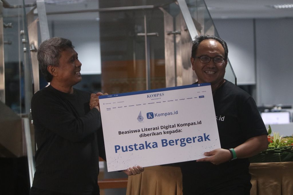 Deputy General Leader of Kompas  Budiman Tanuredjo (right) handed over the Kompas.id Digital Literacy Scholarship to the founder of the Indonesian Mobile Library, Nirwan Ahmad Arsuka (left), in celebration of Kompas.id's 6th Birthday at the Tower Kompas, Jakarta, Wednesday (8/3/2023).