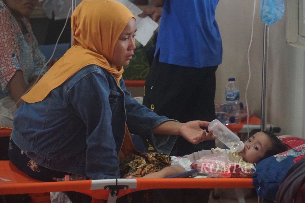 Pemberian air mineral kepada balita pasien kejadian luar biasa (KLB) diare di tempat tidur darurat di lorong bangsal anak RSUD Dr Muhammad Zein Painan, Kabupaten Pesisir Selatan, Sumatera Barat, Rabu (8/5/2024). 