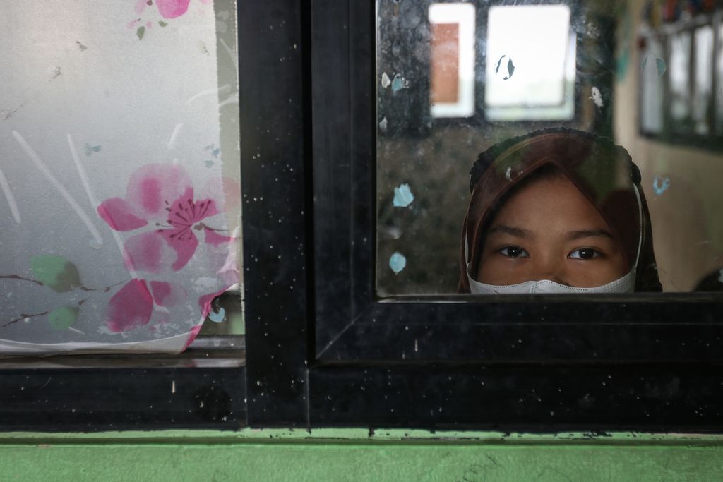 Seorang siswa mengintip melalui jendela di SD Negeri Marunda 05, Cilincing, Jakarta Utara, Rabu (29/3/2023). 