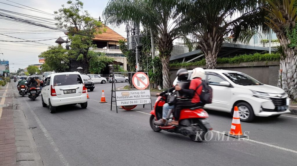 Plang pengumuman penerapan sistem ganjil-genap dan pembatasan mobil barang dipasang di tengah Jalan Suwung Batan Kendal, Denpasar Selatan, Bali, Jumat (11/11/2022).
