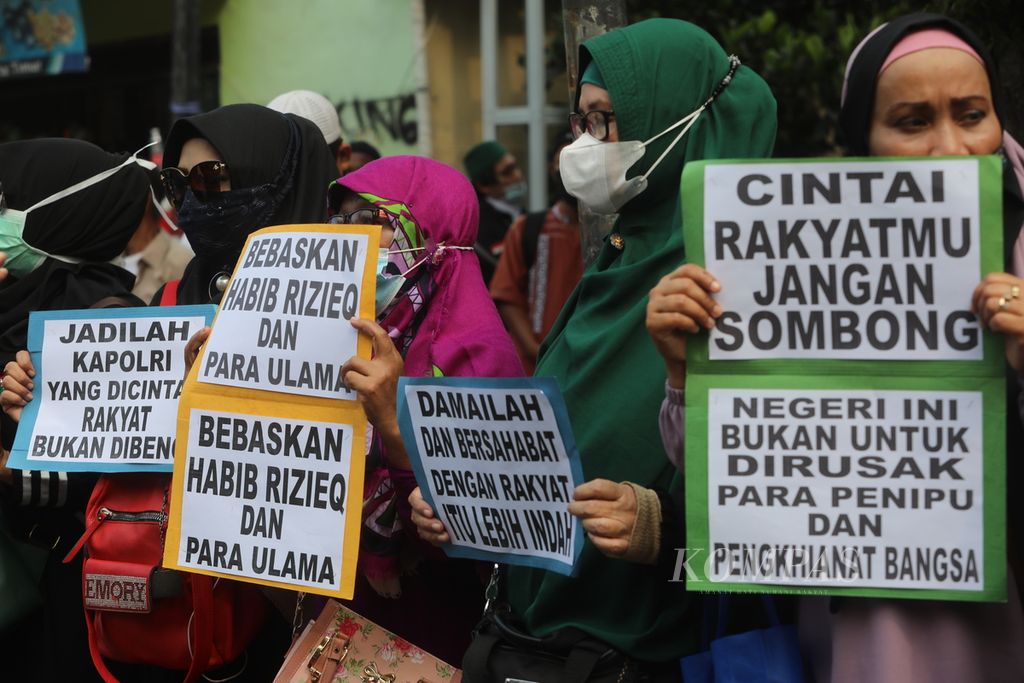 Pendukung Rizieq Shihab menggelar aksi dukungan saat menunggu jalannya sidang lanjutan kasus pelanggaran protokol kesehatan dengan terdakwa mantan imam besar Front Pembela Islam tersebut di luar Pengadilan Negeri  Jakarta Timur, Jakarta, Jumat (26/3/2021). 