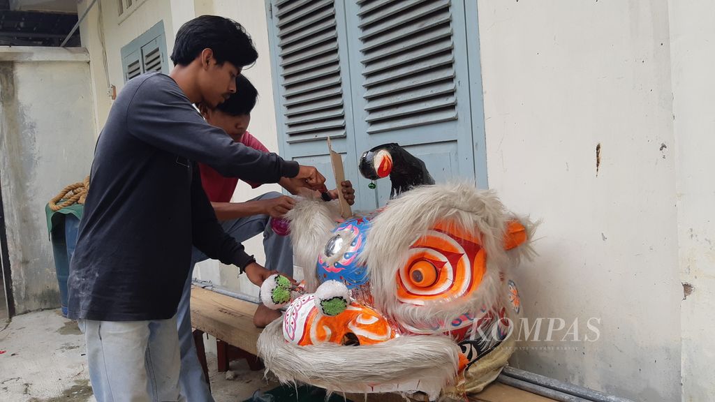 Two men prepare a lion dance head costume in Bandar Lampung, Tuesday (17/2/2023).