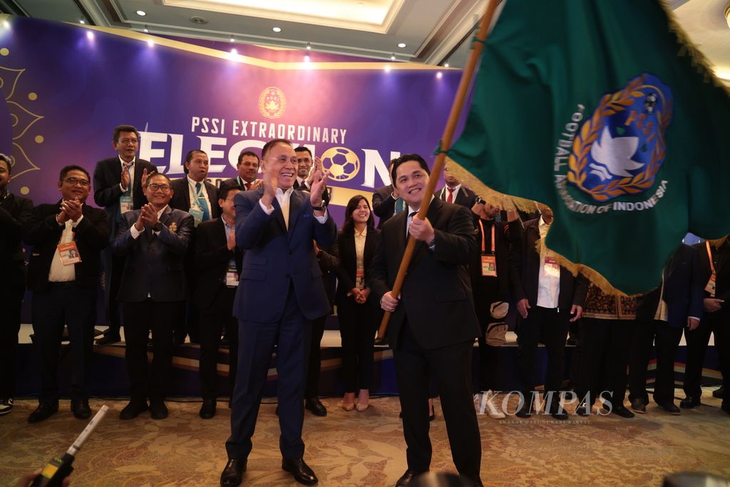 Ketua Umum PSSI periode 2024-2027 Erick Thohir mengibarkan bendera PSSI yang diberikan Ketua Umum PSSI periode 2019-2023 Mochamad Iriawan (kiri) saat serah terima jabatan seusai Kongres Luar Biasa PSSI di Jakarta, Kamis (16/2/2023).
