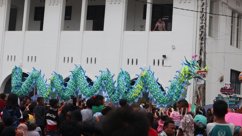 Masyarakat menyaksikan atraksi liong dalam acara Cap Go Meh di sejumlah ruas jalan Kota Cirebon, Jawa Barat, Minggu (5/2/2023). 