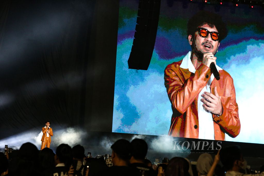 Penyanyi Kunto Aji mengajak penonton menyanyikan lagu Indonesia Raya dalam Raisa Live in Concert di Stadion Utama Gelora Bung Karno, Jakarta, Sabtu (25/2/2023).