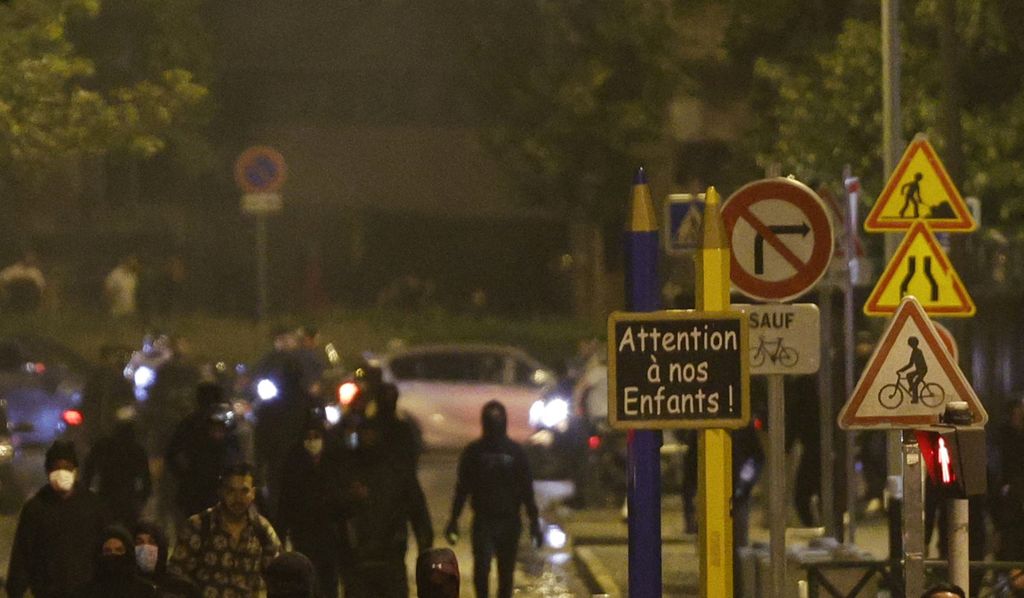 Sebuah rambu bertuliskan "Perhatikan Anak-anak Kita" terlihat saat massa berunjuk rasa di Nanterre, sebelah barat Paris, Perancis, 28 Juni 2023, sehari setelah tewasnya seorang remaja akibat ditembak polisi. 