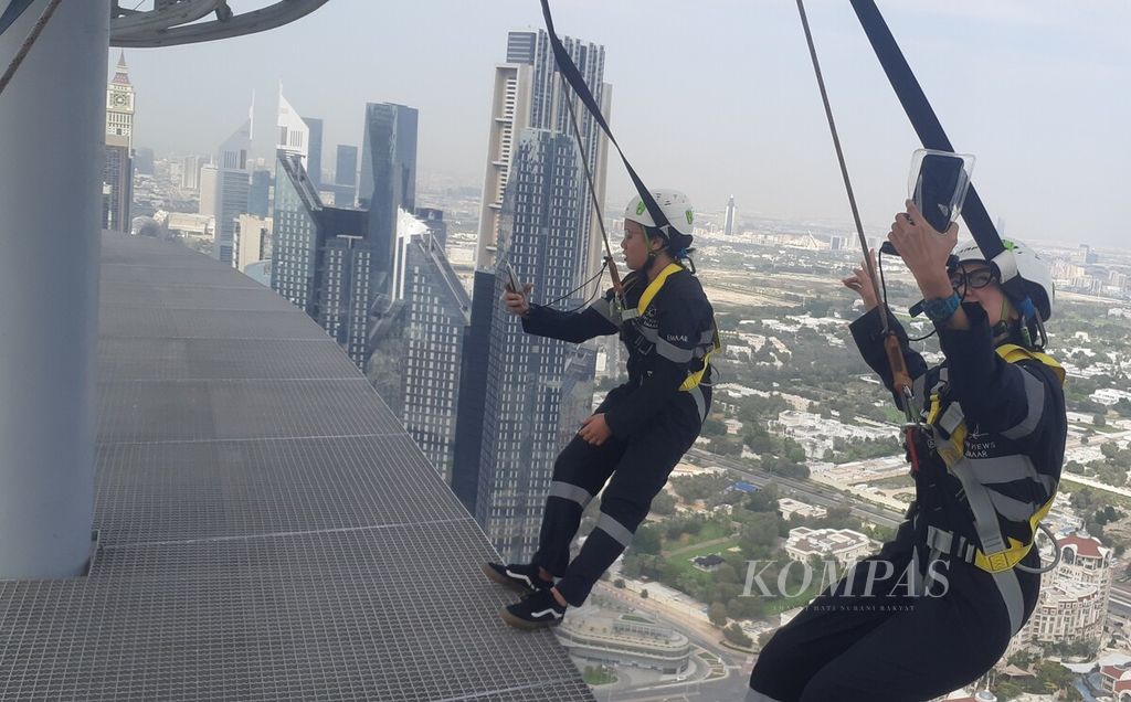Dua perempuan jurnalis Indonesia berdiri dengan hanya berpijak di ujung sisi balkon gedung pencakar langit Sky View di ketinggian 219,5 meter di kota Dubai, Uni Emirat Arab, Sabtu (23/3/2024). Wisata menantang ini dilakukan di ketinggian 219,5 meter dari permukaan tanah.