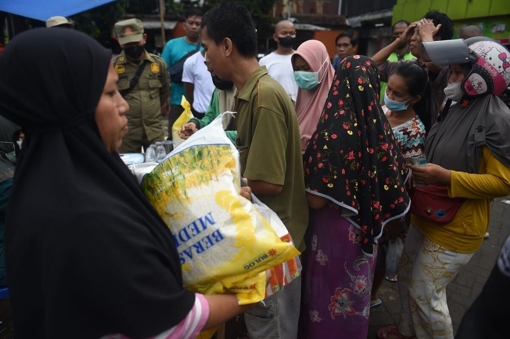 Warga membeli beras medium saat operasi pasar di Pasar Kembang, Surabaya, Minggu (5/2/2023). Operasi pasar berlangsung pada 4-5 Februari di 12 pasar di Kota Surabaya. Beras medium dijual Rp 46.000 per 5 kg. Warga dibatasi membeli hanya 10 kg beras.