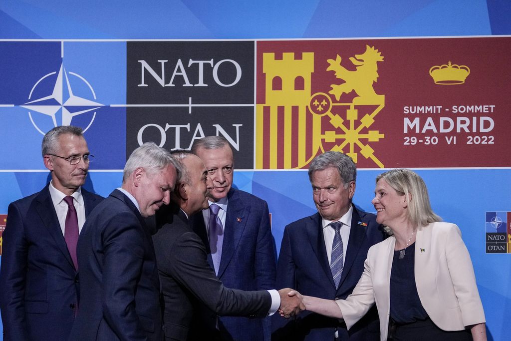Menteri Luar Negeri Turki Mevlut Cavusoglu (tiga dari kiri) berjabat tangan dengan Perdana Menteri Swedia Magdalena Andersson (kanan) disaksikan Presiden Turki Recep Tayyip Erdogan (tiga dari kanan), Presiden Finlandia Sauli Siniisto (dua dari kanan), dan Sekjen NATO Jens Stoltenberg (kiri) seusai menandatangani Nota Kesepahaman soal Keanggotaan Swedia dan Finlandia ke NATO di Madrid, Spanyol, Selasa (28/6/2022).
