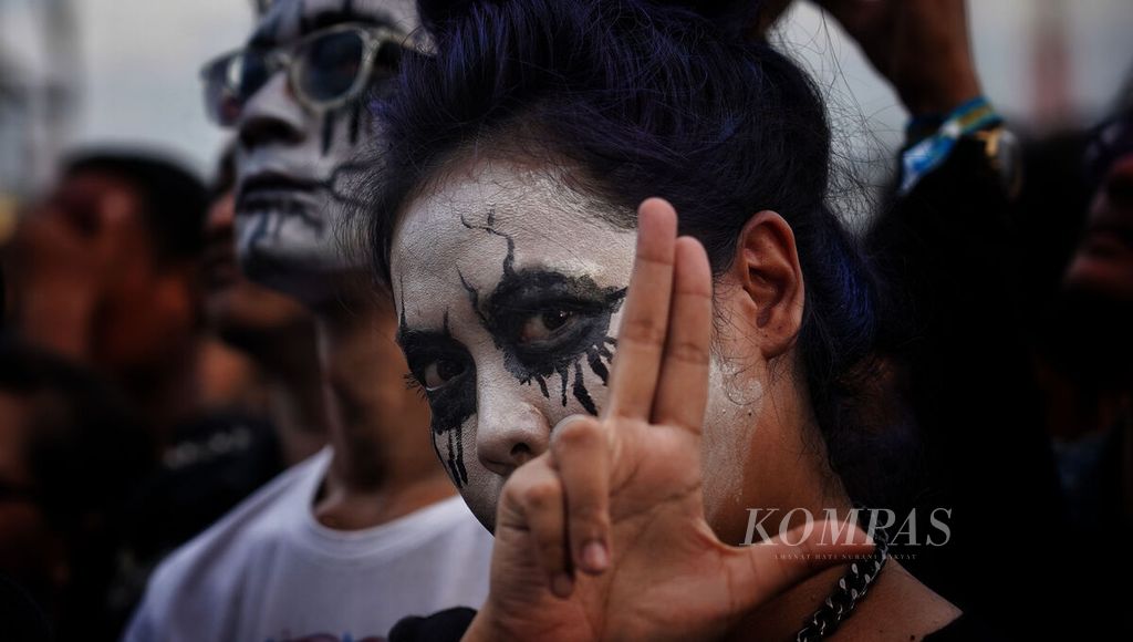 Penonton yang merias wajahnya saat acara Hammersonic Festival 2023 di Jakarta International E-Prix Circuit, Ancol, Jakarta Utara, Minggu (19/3/2023). 