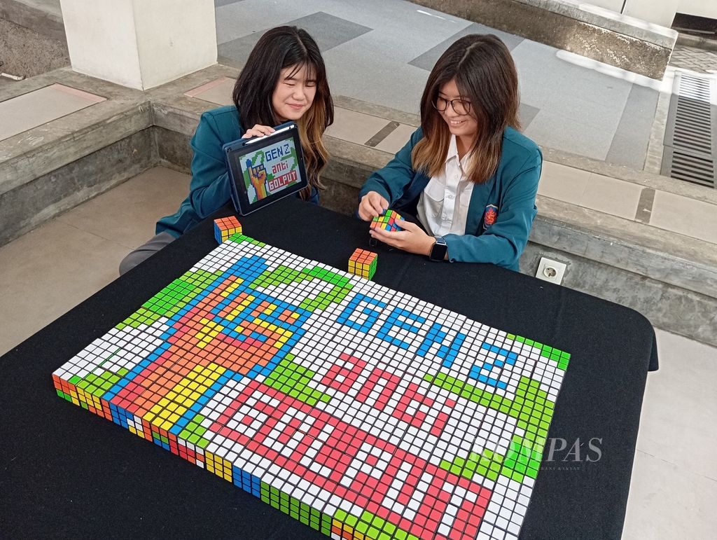 Two female students from the University of Surabaya arranged 150 rubik cubes as an installation for a campaign aimed at voters, especially the Z generation, to exercise their right to vote in the General Election on February 14, 2024.