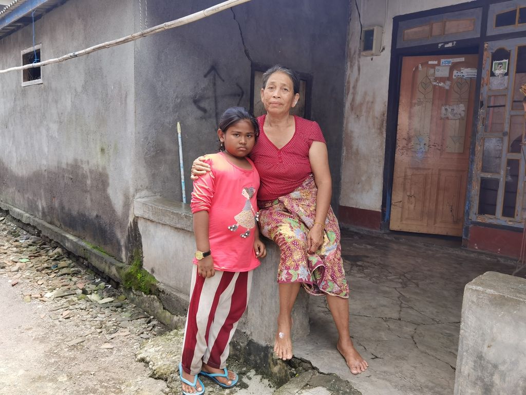 Mariam (50) bersama cucunya, Nadira (8), di Dusun Mungkik, Desa Pandan Wangi, Kecamatan Jerowaru, Kabupaten Lombok Timur, Nusa Tenggara Barat, Rabu (3/3/2021). Sejak masih balita, Nadira sudah ditinggal pergi orangtuanya menjadi pekerja migran dan tinggal bersama neneknya.