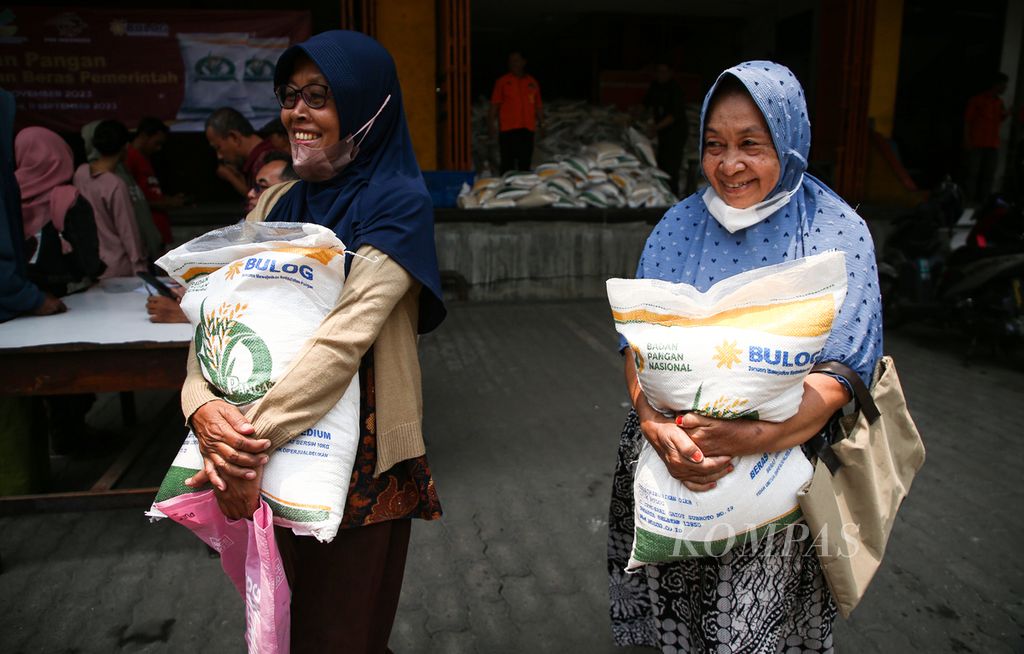 Warga tersenyum saat menerima bantuan sosial beras di Kantor Pos Tanjung Priok, Jakarta Utara, Selasa (19/9/2023). Beras bantuan seberat 10 kilogram tersebut dirasakan sangat membantu warga di tengah harga beras yang tinggi.