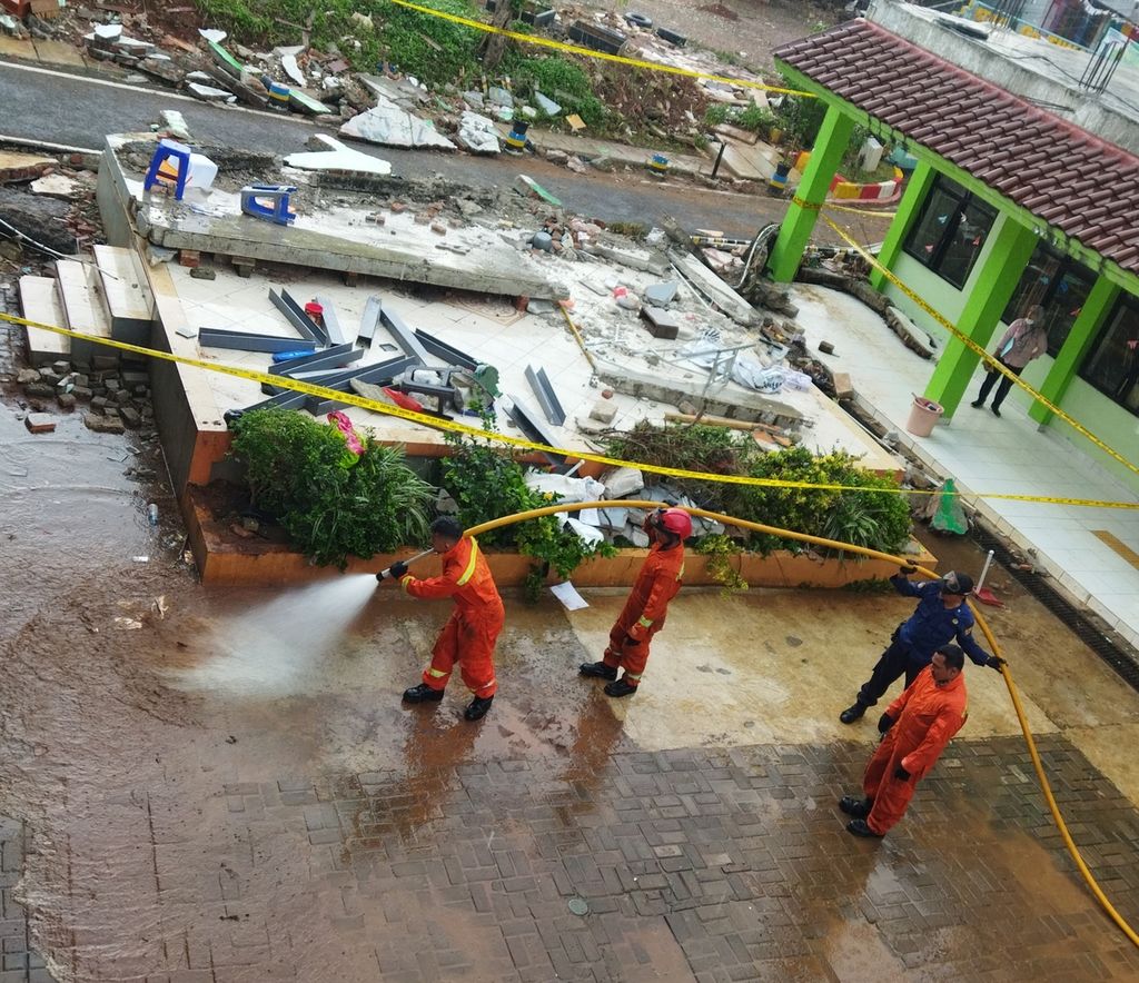 Petugas pemadam kebakaran membantu membersihkan halaman sekolah MTsN 19, Jumat (7/10/2022), dampak dari banjir pada Kamis (6/10/2022) kemarin.